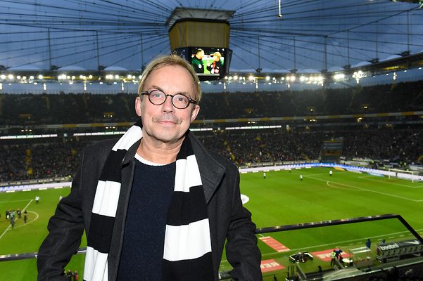 Mann steht mit Eintrachtschal im Stadion der Eintracht