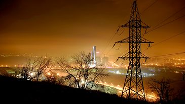 © www.istock.com - voffkatw Strommast bei Nacht im Hintergrund beleuchtete Skyline