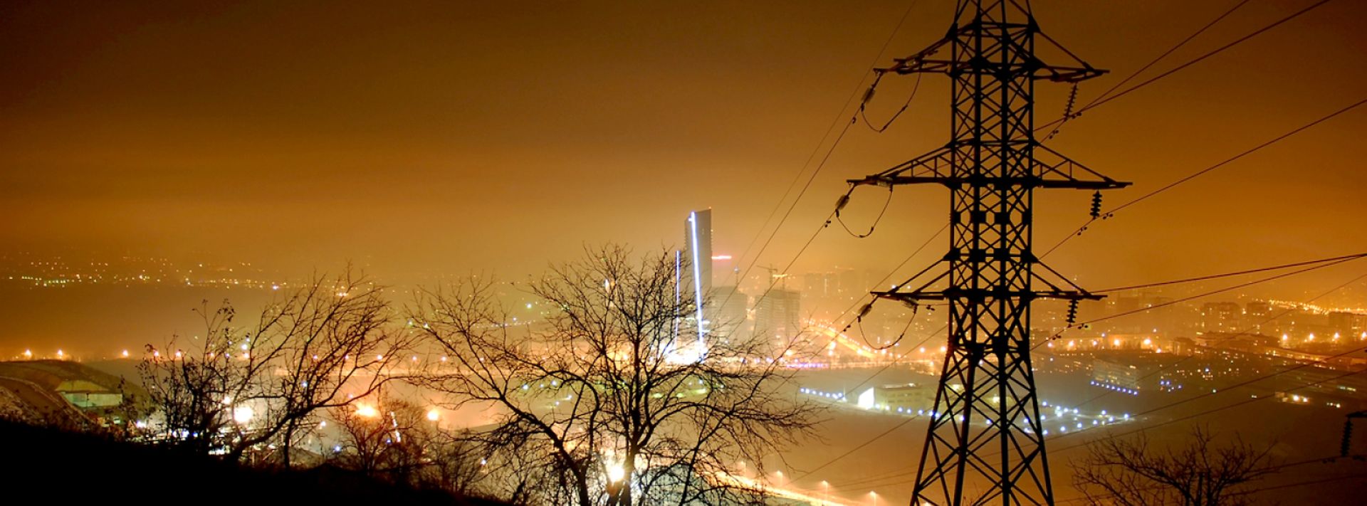 © www.istock.com - voffkatw Strommast bei Nacht im Hintergrund beleuchtete Skyline