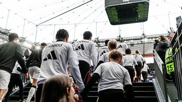 Einlaufkinder an den Händen von Eintrachtspielern auf dem Weg ins Stadion