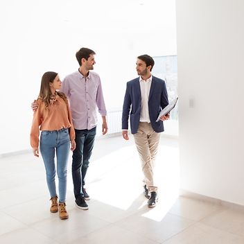 © www.istock.com - ruizluquepaz Immobilienmakler führt ein junges Paar durch eine leer stehende Wohnung
