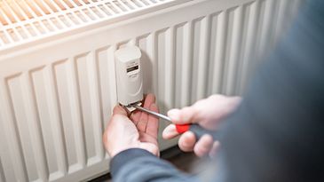 © www.istock.com - audioundwerbung Zwei Hände, die mit einem Schraubendreher einen Heizkostenverteiler am Heizkörper befestigen
