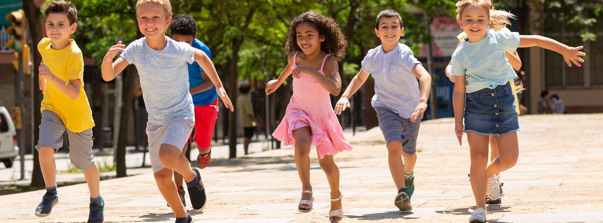 Kinder rennen glücklich auf einem Weg zwischen Bäumen