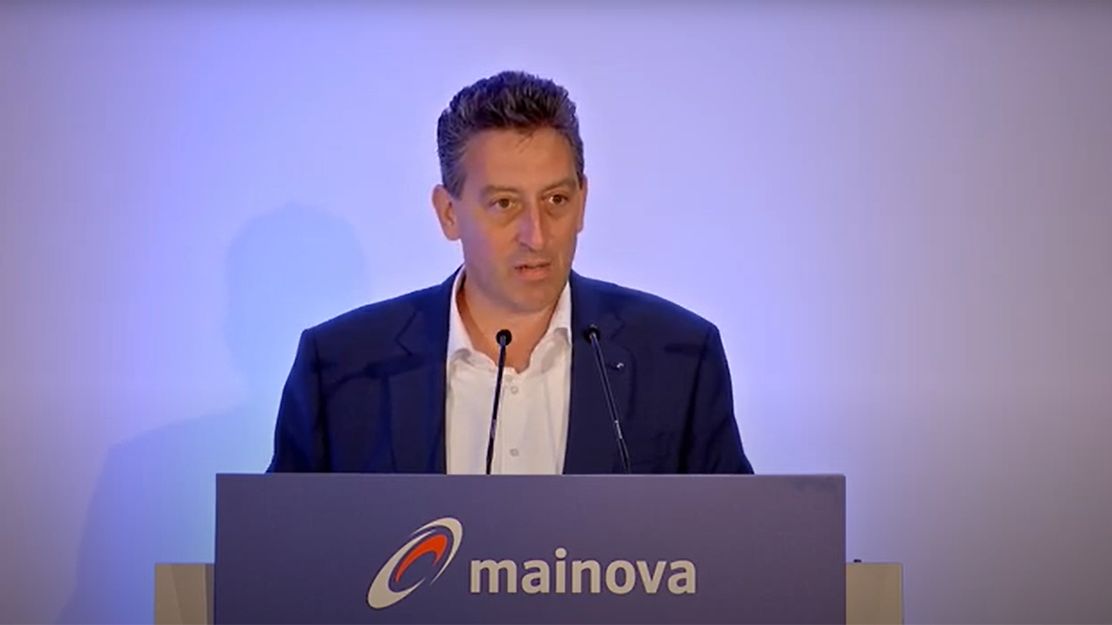 © Mainova Dr. Maxelon steht hinter einem Rednerpult mit dem Logo und Schriftzug "mainova".