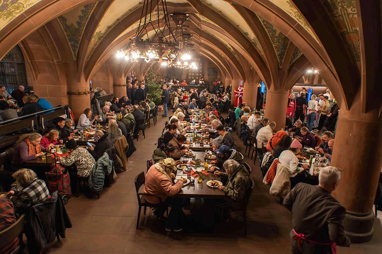 Viele Personen sitzen zusammen im Ratskeller des Frankfurter Römers zu einem Weihnachtsgansessen.