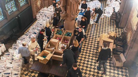 Helfer packen Pakete mit Präsenten im Ratskeller des Frankfurter Römers