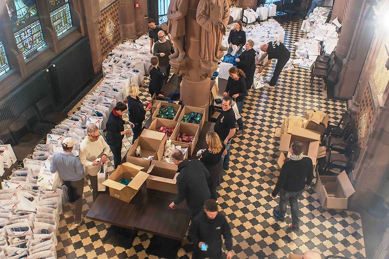 Helfer packen Pakete mit Präsenten im Ratskeller des Frankfurter Römers