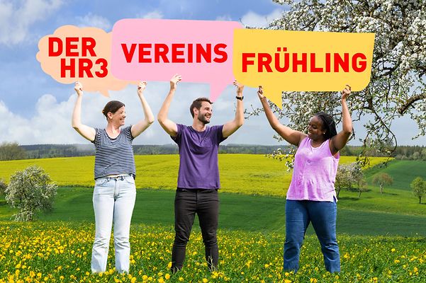 Drei Personen halten bunte Sprechblasen mit „Der HR3 Vereinsfrühling“ in einer blühenden Frühlingslandschaft hoch.