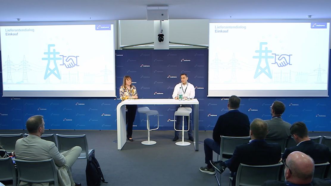 Vortrag beim Lieferantendialog Einkauf mit zwei Personen auf Bühne vor Publikum und Präsentationsfolien. 