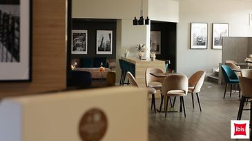 Modern eingerichteter Hotel- oder Loungebereich mit Tischen, Sesseln und gemütlichen Sitznischen.