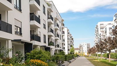 © stock.adobe.com/ah_fotobox Moderne Wohnsiedlung mit Grünflächen und gepflastertem Weg