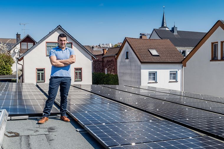 Mann steht neben Solaranlagen