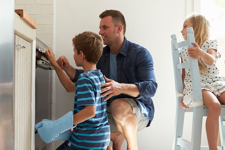 © iStock.com/monkeybusinessimages Energie bewusst nutzen: Familie prüft Herd