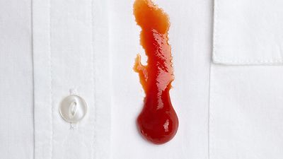 © iStock.com/Picsfive Detailaufnahme: Ketchup-Fleck auf einem weißen Hemd