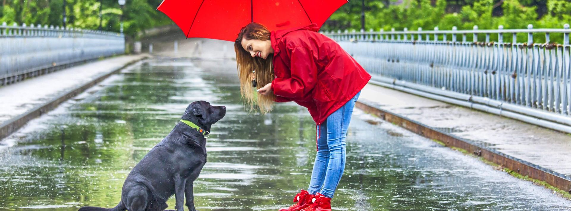 Frau mit Hund draußen bei Regen