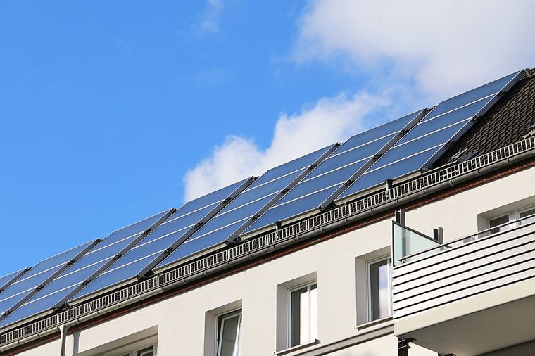 Viele Solarpanele großflächig auf einem Dach angebracht
