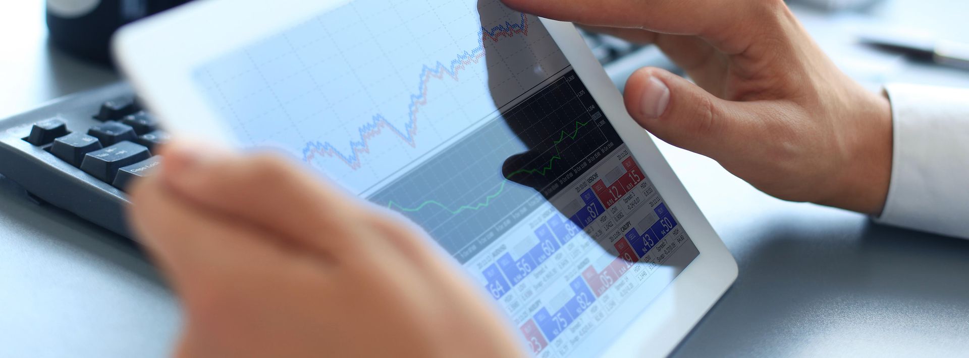 © stock.adobe.com/ty Mann hält Tablet in der Hand, auf dem eine Aktienkursentwicklung gezeigt wird.