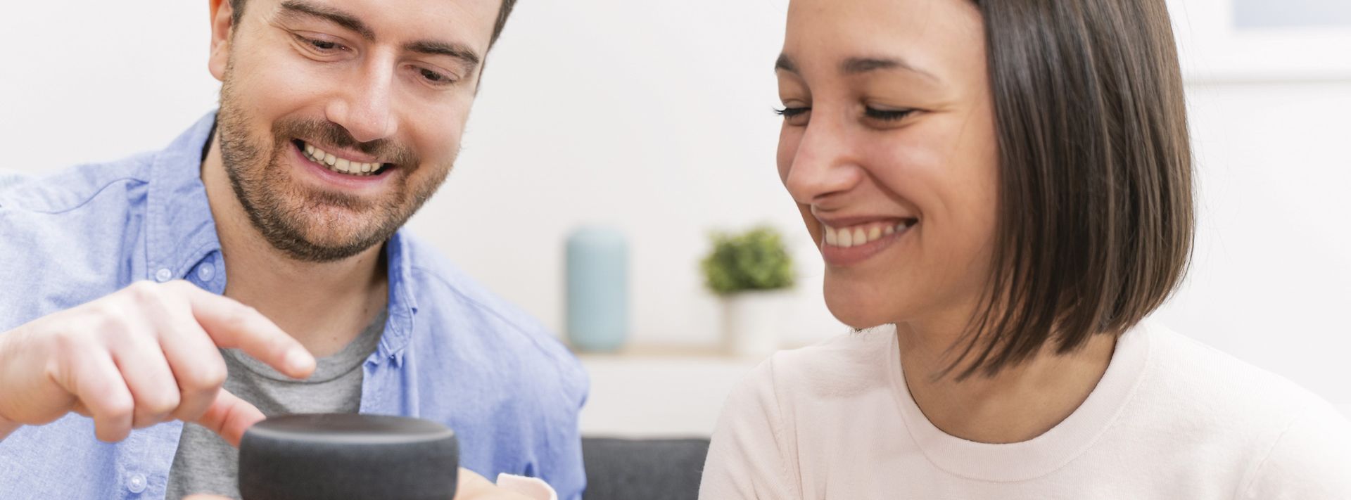 © stock.adobe.com/Paolese Mann und Frau bedienen einen Sprachassistenten.