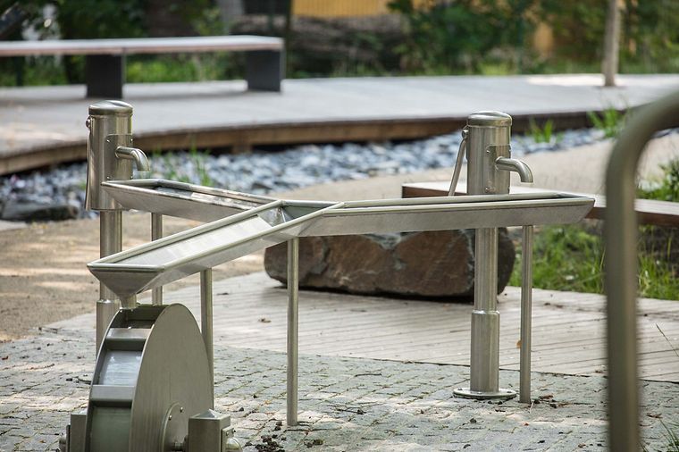 Ein Wasserspielplatz mit zwei Pumpen und einem Wasserlauf.