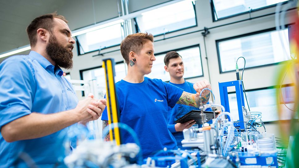 Ausbilder prüft die Messarbeit einer Auszubildenden