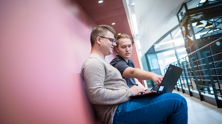 © Mainova/AndreFormer Ausbilder sitzt mit Notebook und bekommt vom Auszubildenden etwas am Monitor gezeigt