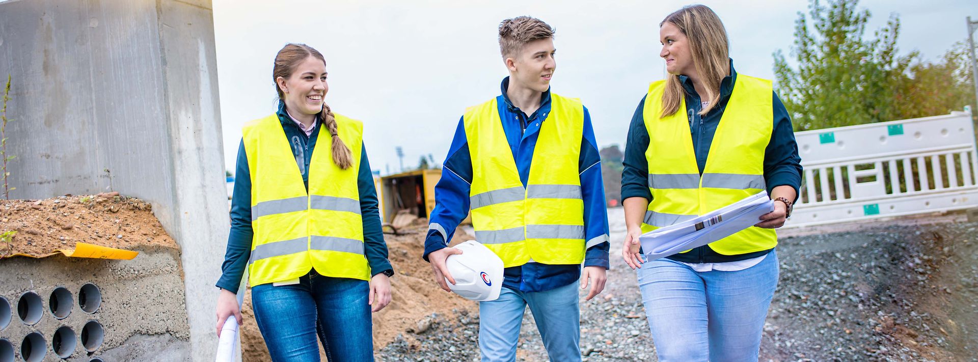 © Mainova/AndreFormer Gruppe Auszubildender läuft durch eine Baustelle und sprechen miteinander