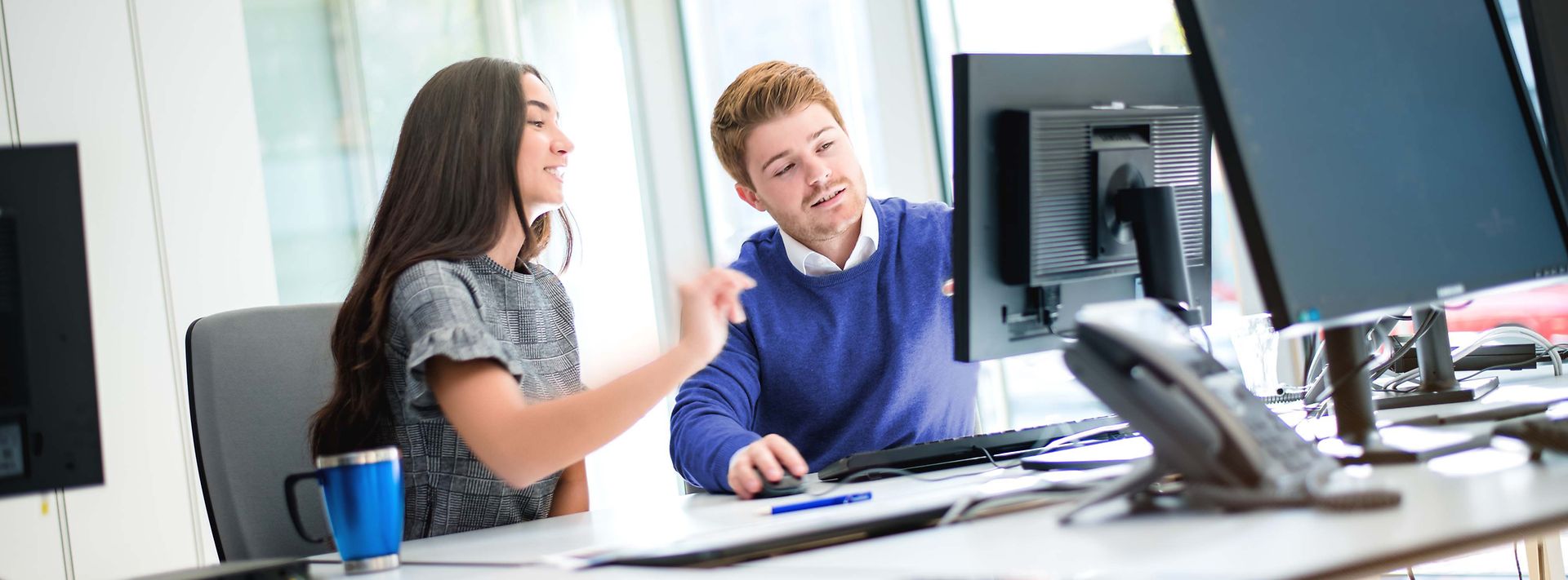 © Mainova/AndreFormer Zwei Studierende sitzen am Monitor und besprechen den Sachverhalt am Monitor