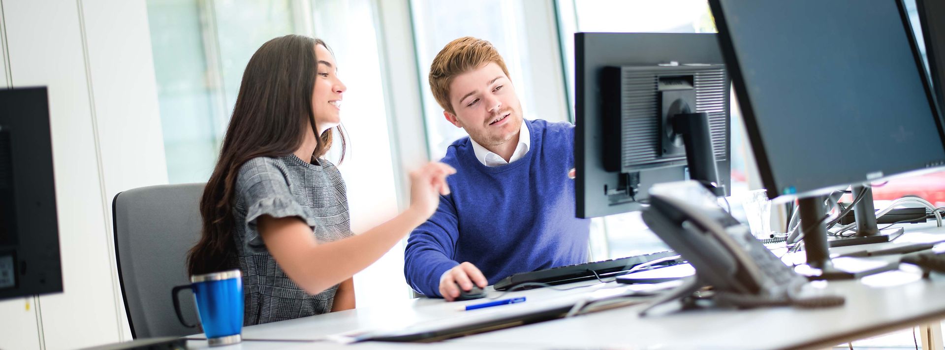 © Mainova/AndreForner Zwei Studierende sitzen am Monitor und besprechen den Sachverhalt am Monitor