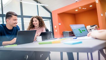 Auszubildende sitzen zusammen am Notebook 