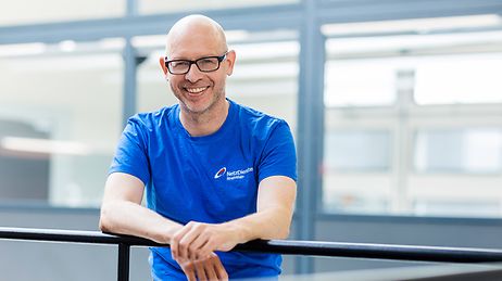 © Mainova/AndreFormer Holger Hustedt angelehnt an einem Gelände im Ausbildungszentrum