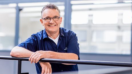 © Mainova/AndreFormer Matthias Löw angelehnt an einem Gelände im Ausbildungszentrum